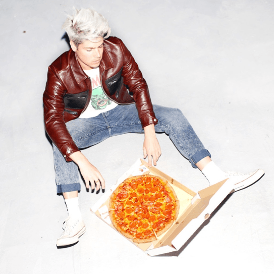 Eating pizza and wearing Coach, the casual "it" guy. Image from Yummertime